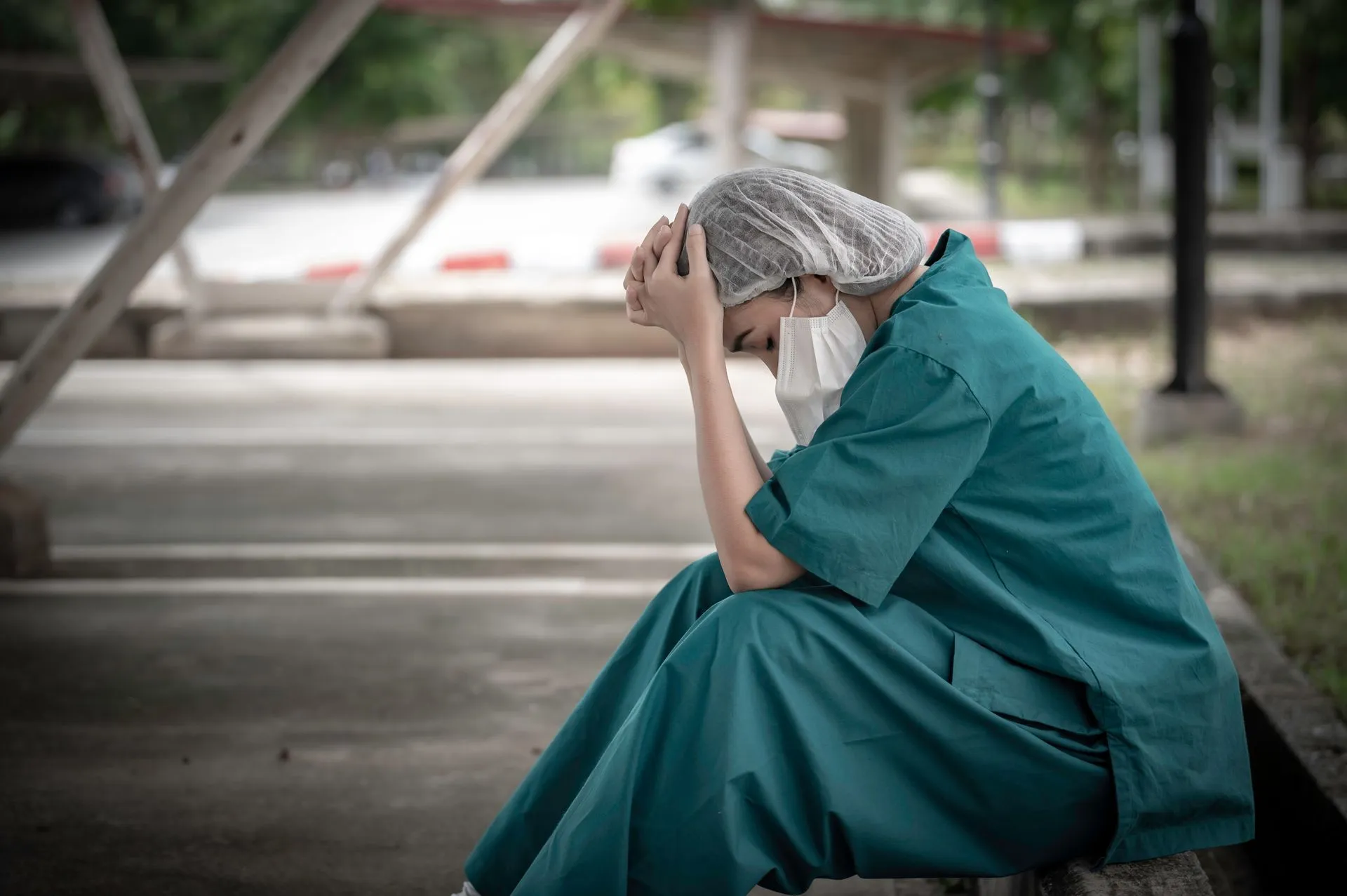 stock-photo-tired-depressed-female-asian-scrub-nurse-wears-face-mask-blue-uniform-sits-on-hospital-floor-young-2132738911-1920w